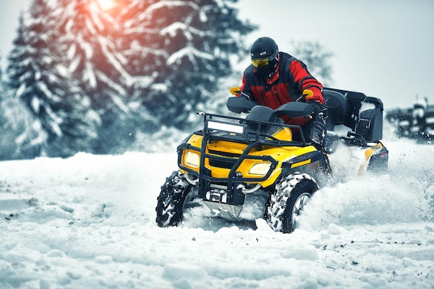 Rider driving in the quadbike race in winter in the forest