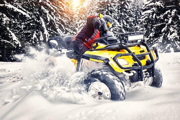 Rider driving in the quadbike race in winter in the forest