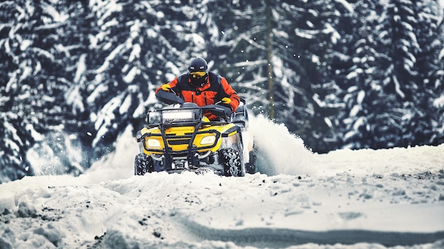 Rider driving in the quadbike race in winter in the forest