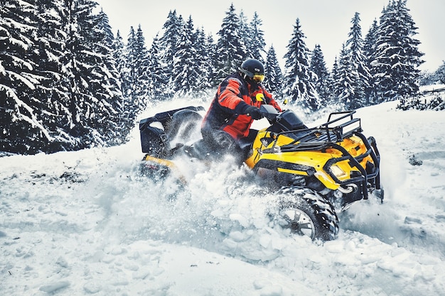 Pilota che guida nella gara di quad in inverno nella foresta