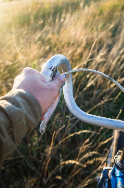 Riding a bicycle in nature on a country road the hand that\
controls the steering wheel of a bicycle blurred motion