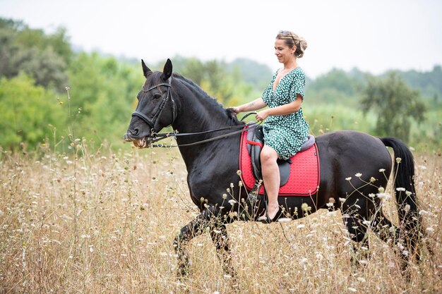 Riding girl are walking with her black horse