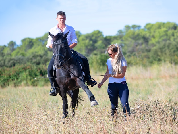 Riding teenager, teacher and horse