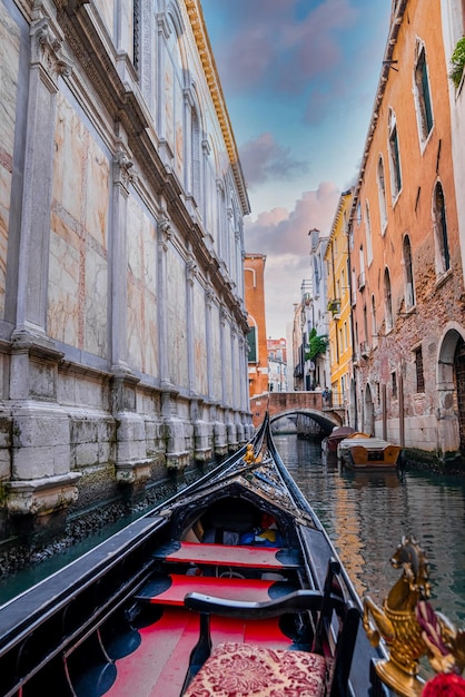 Photo riding a traditional gondola down the narrow canals in venice italy