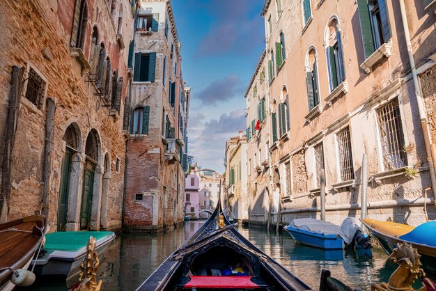 Riding a traditional gondola down the narrow canals in venice italy