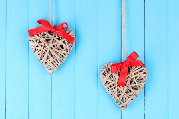 Rieten harten met rode strik op houten achtergrond
