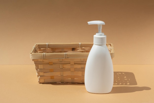 Rieten mand en witte dispenserfles voor cosmetische spaproducten op een beige achtergrond