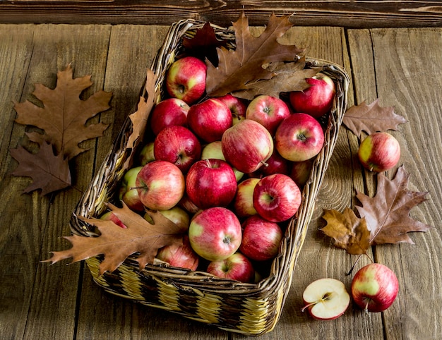 Rieten mand met appels op een houten tafel