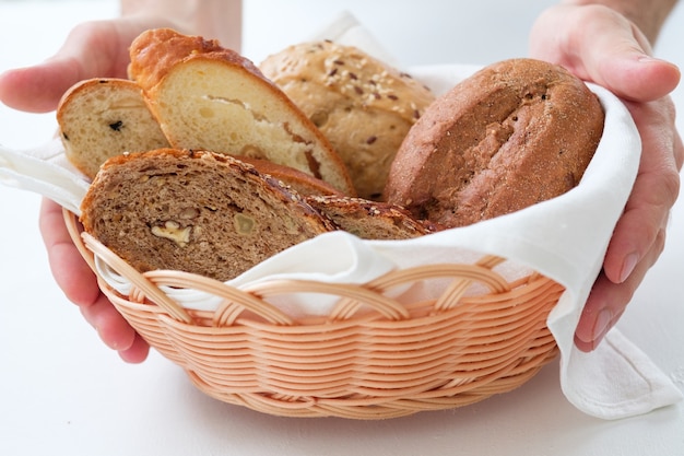 Rieten mand met broodassortiment in handen.