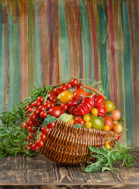 Rieten mand met diverse kleurrijke groenten Verse rode tomaten in mand in de keuken