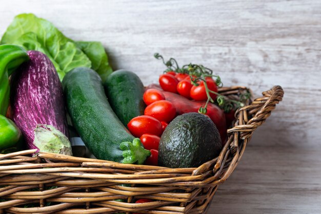 Rieten mand met verse groenten gezonde voeding voor de zomer