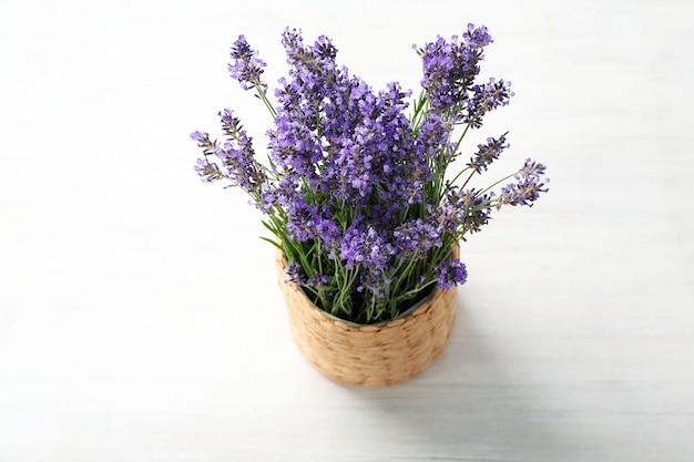 Rieten pot met lavendel op houten achtergrond