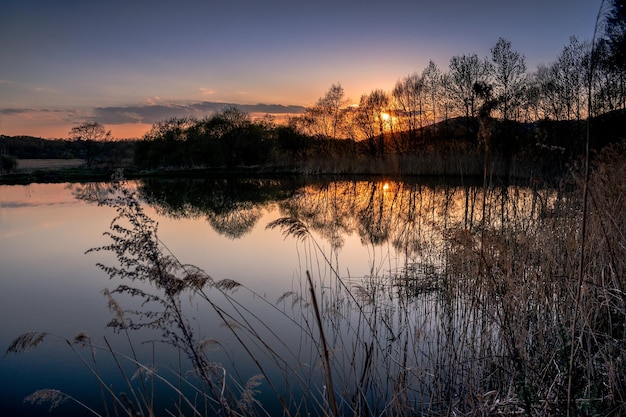 Rietmeer met een reflecterend oppervlak bij zonsondergang