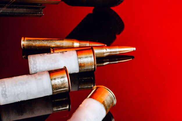 Rifle bullets or cartridges on black shiny background close up