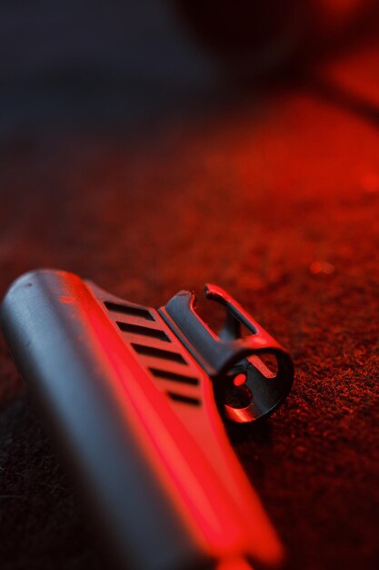 Rifle gun with air pellets for hunting on cloth dark background with red light illumination of the muzzle and pallet