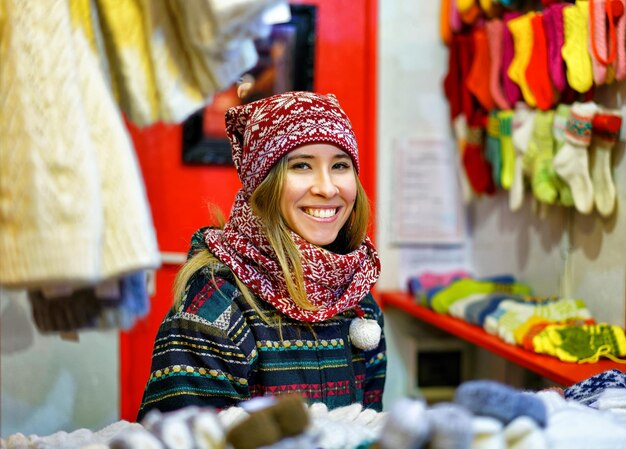 Riga, Latvia - December 24, 2015: Smiling young woman pictured at one of the stalls during Riga Christmas Market. The market took place from late November till the start of January.