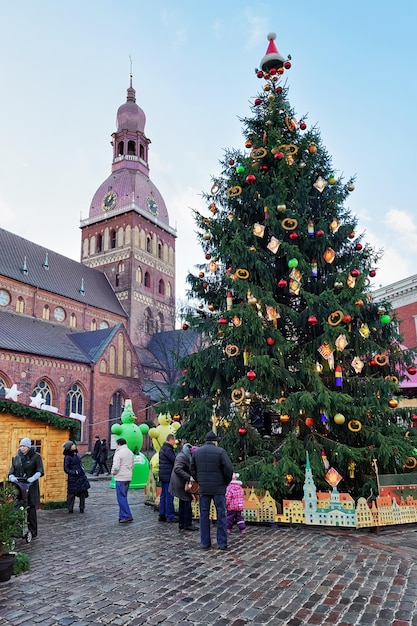 Riga, latvia - december 25, 2015: people near christmas tree at
the christmas market in the dome square in the center of old riga,
latvia.