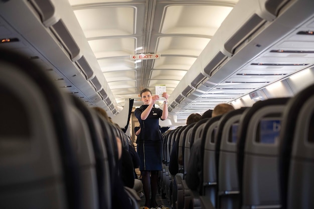 Riga Letland 03 april 2019 Stewardessen in de cabine van het passagiersvliegtuig instrueren passagiers over veiligheidsmaatregelen in geval van nood vóór de vlucht van Riga RIX naar Zürich Kloten ZRH