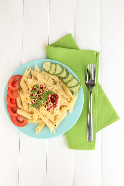 Rigatoni pasta dish with tomato sauce on white wooden table