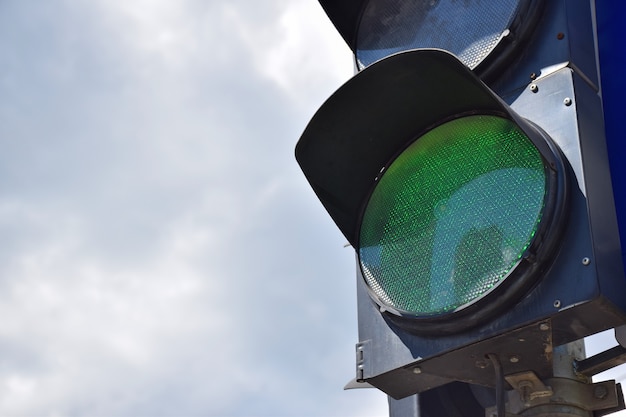 On the right side of the frame, there is a traffic light with a glowing green light against the sky. There is a place on the left for an inscription