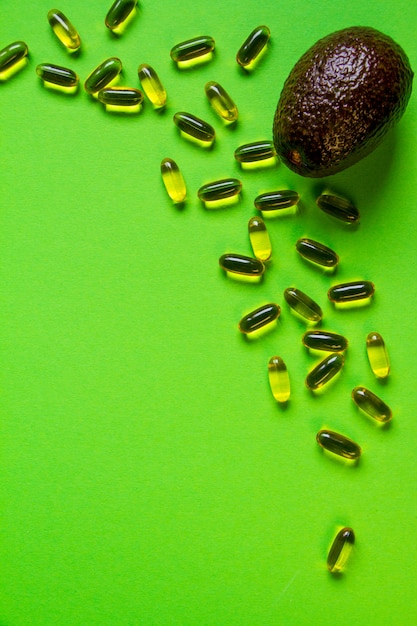 Foto rij avocado en veel capsules met avocado-olie