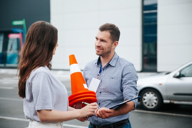 Rij-instructeur die plastic kegels verzamelt