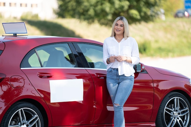 Rij-instructeur leunend op haar auto