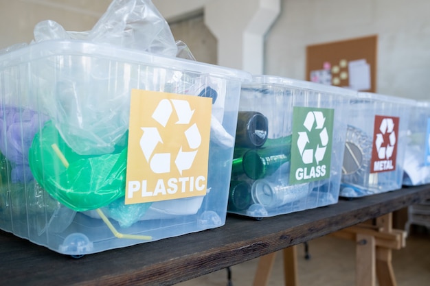 Rij plastic containers met recyclebare donatie op zwarte tafel