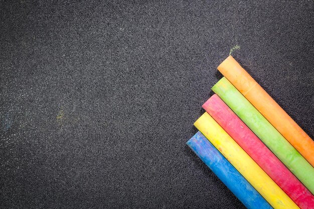 Rij regenboogkleurige krijt op het bord