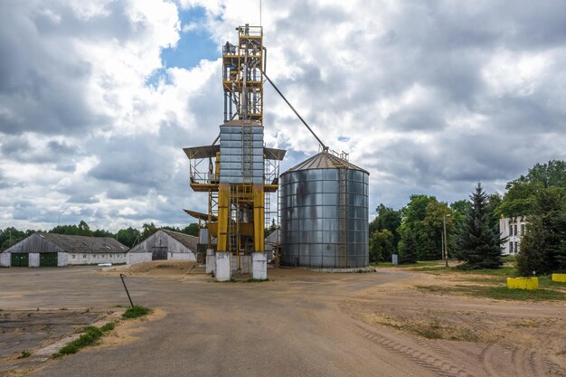 Rij van agrosilo's graanschuurlift met zadenreinigingslijn op agroprocessing-fabriek voor verwerking van droogreiniging en opslag van landbouwproducten