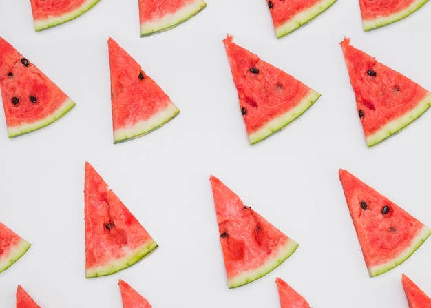 Foto rij van driehoekige watermeloenplakken op witte achtergrond