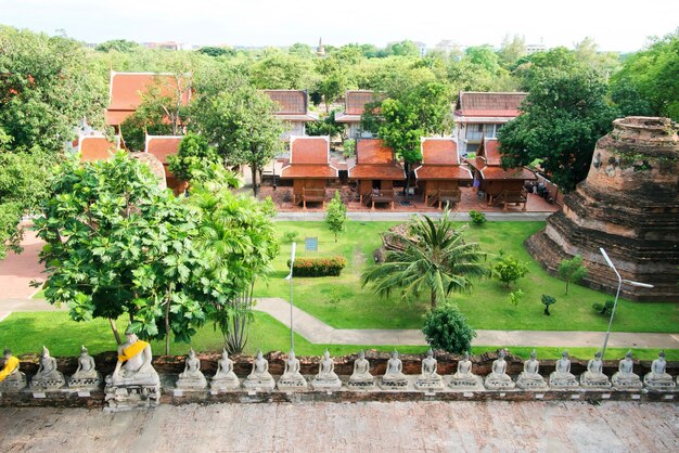 Rij van het standbeeld en de pagode van boedha in wat yai chaimongkol, ayutthaya, thailand.