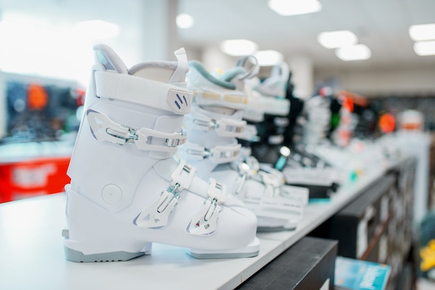 Rij van ski- en snowboardschoenen in sportwinkel, close-up.