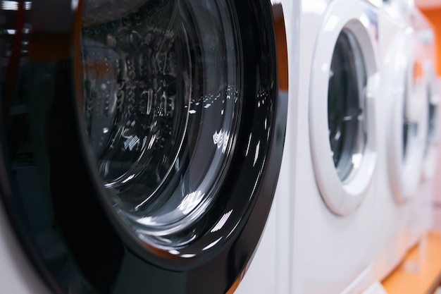 Rij wasmachines te koop in een winkel voor huishoudelijke apparaten, close-up met onscherpe achtergrond