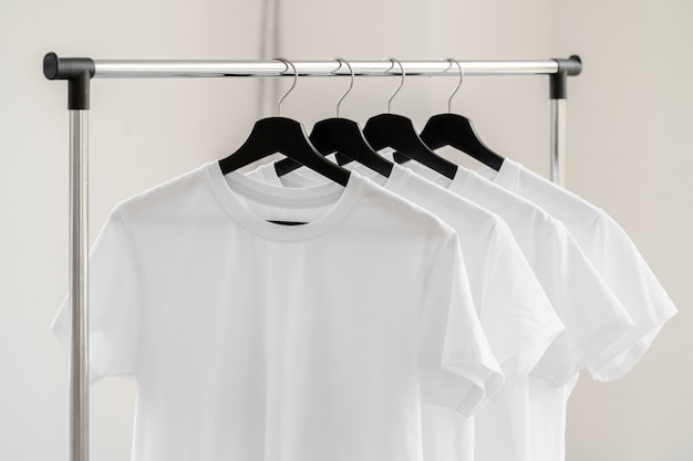 Rij witte t-shirts op hangers op rek