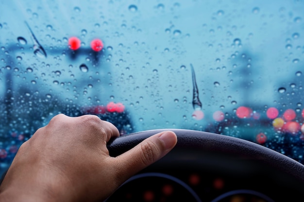 Rijden in regenachtige dag. slecht weer op de weg met wazig licht en verkeersopstopping in de stad