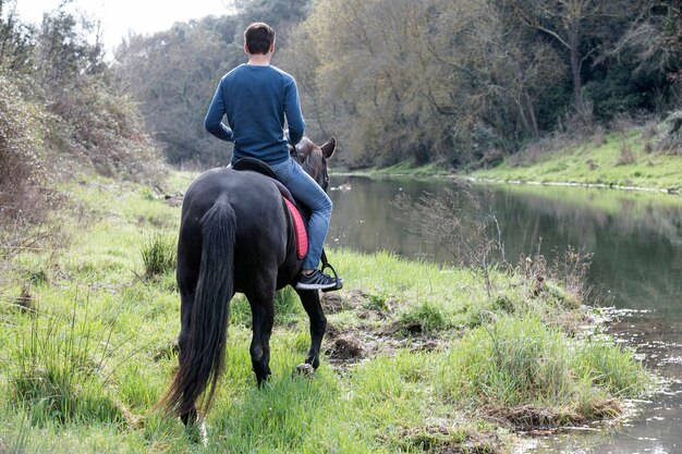 Rijdende man traint haar zwarte paard