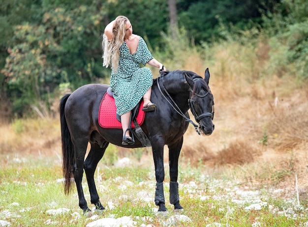 Foto rijdende meid loopt met haar zwarte paard