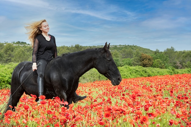 Rijdende meid traint haar zwarte paard