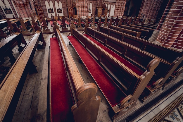 Rijen kerkbanken bij de oude Europese katholieke kerk