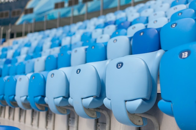 Rijen van blauwe zetels bij voetbalstadion.