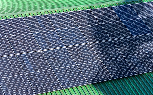 Rijen zonnepanelen op daken bedekt met gepatineerde trapeziumvormige koperen platen