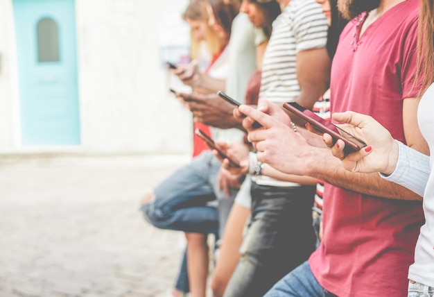 Rijn van mensen die smartphones gebruiken terwijl ze buiten staan