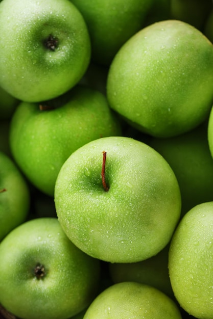 Rijp fruit van een groene appel in close-up met dauwdruppels. Sappig fruit In volledig scherm