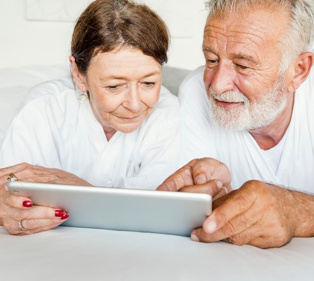 Rijp paar dat een tablet gebruikt