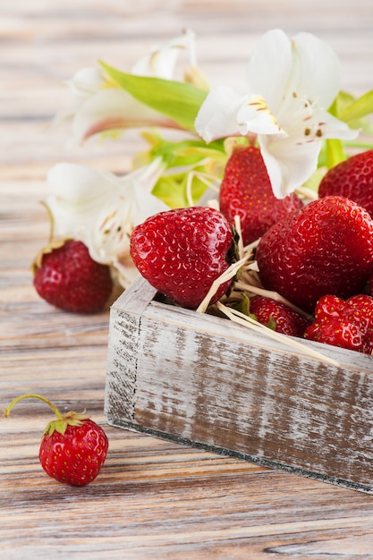 Rijpe aardbeien en witte leliebloemen