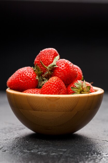 Rijpe aardbeien in houten kom