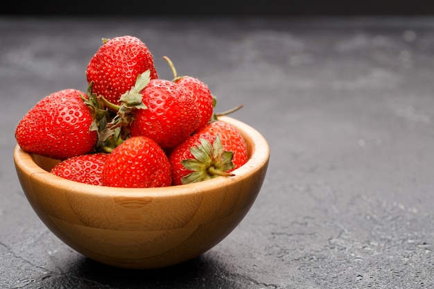 Rijpe aardbeien in houten kom