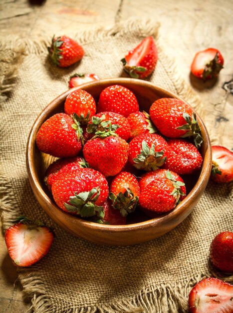 Rijpe aardbeien in kom op een zak