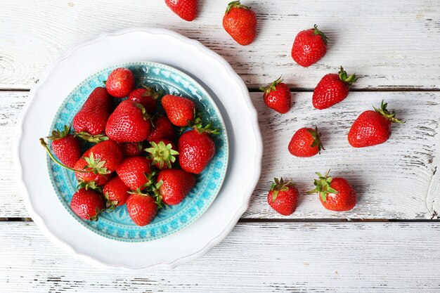 Rijpe aardbeien in plaat op houten tafel